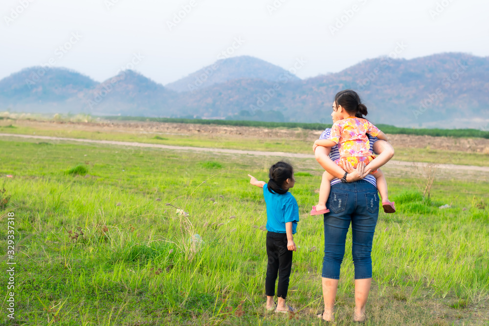 Mother and two children standing in the meadow Mother and two children standing in the meadow