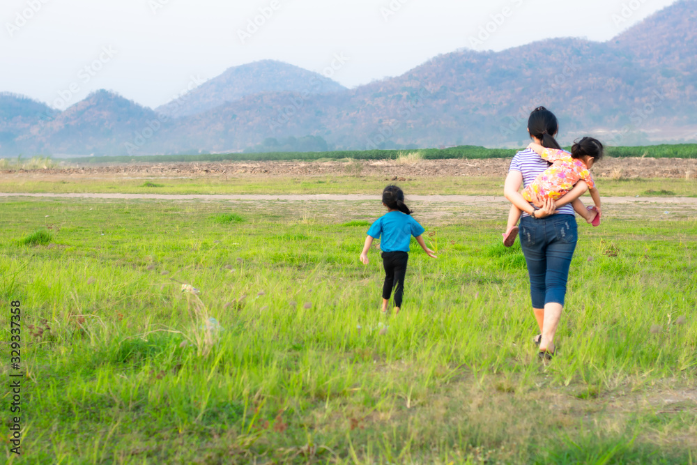 Mother and two children standing in the meadow Mother and two children standing in the meadow