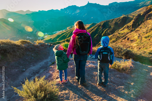 happy family -mother with kids- travel in sunset mountains