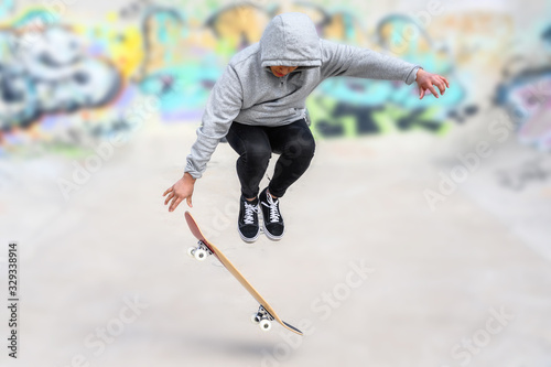 young skater doing jump trick at skate park .
