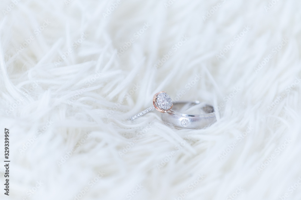 Obraz premium The diamond wedding ring for the bride and groom's wedding ring is made of white gold. And large high-value diamonds lay on the woolen rug Concept of important, wedding day celebration