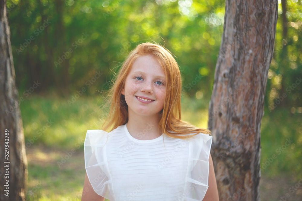 red-haired girl in a white dress walks in the park red-haired girl in a white dress walks in the park