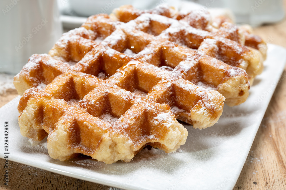 Tasty Belgian dessert, Brussels waffles with syrup and white sugar powder