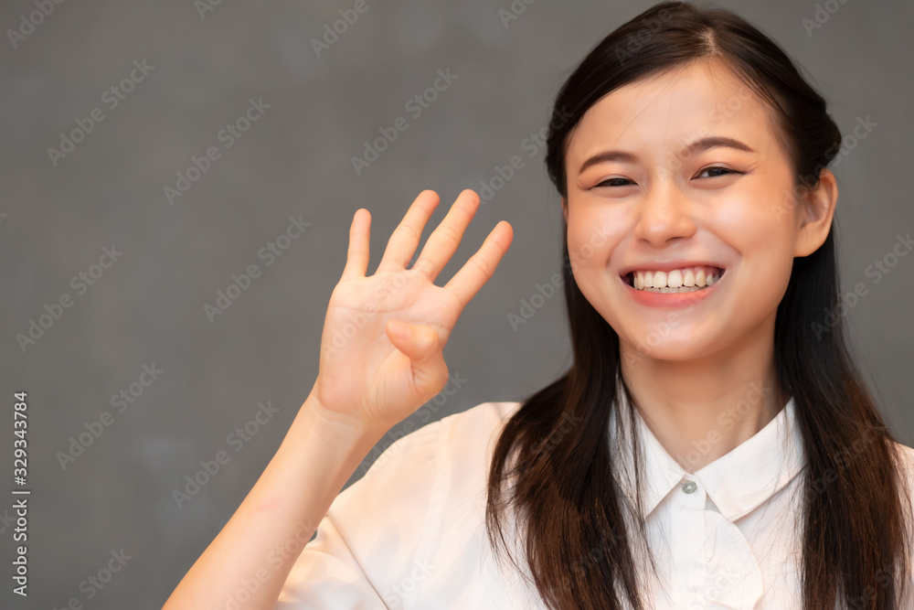 asian woman pointing, counting four finger; portrait of positive happy  smiling asian woman pointing up 4