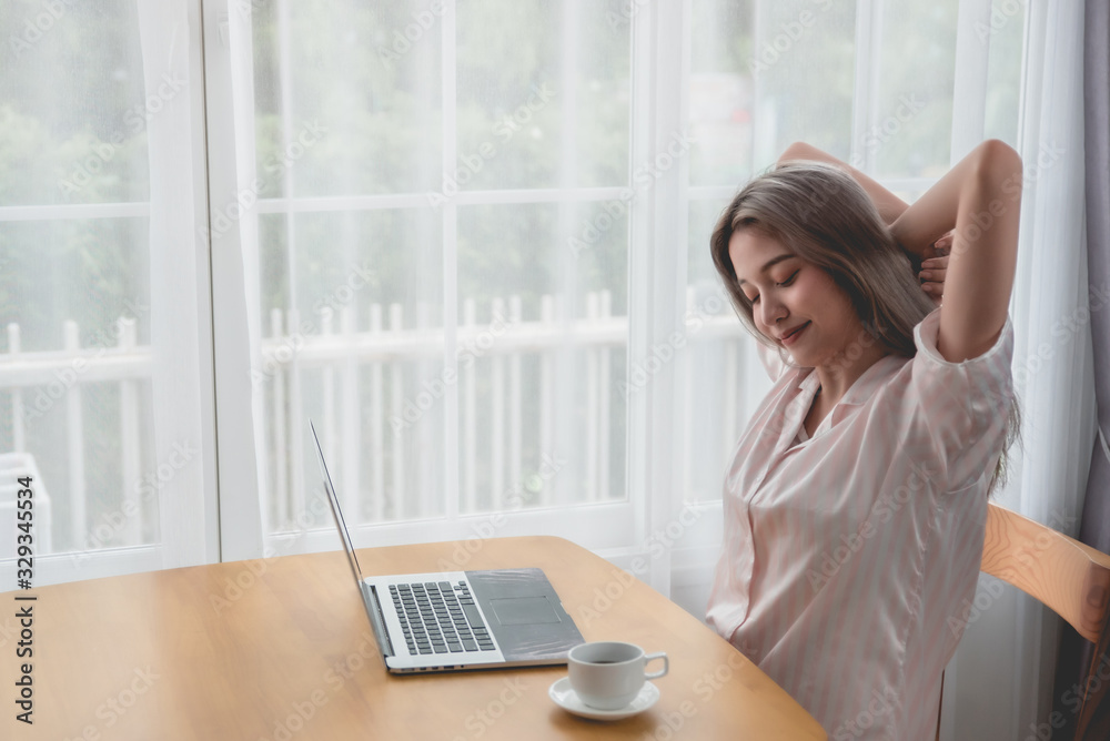 Lazy bored asian woman using laptop in the morning. Lazy bored asian woman using laptop in the morning.