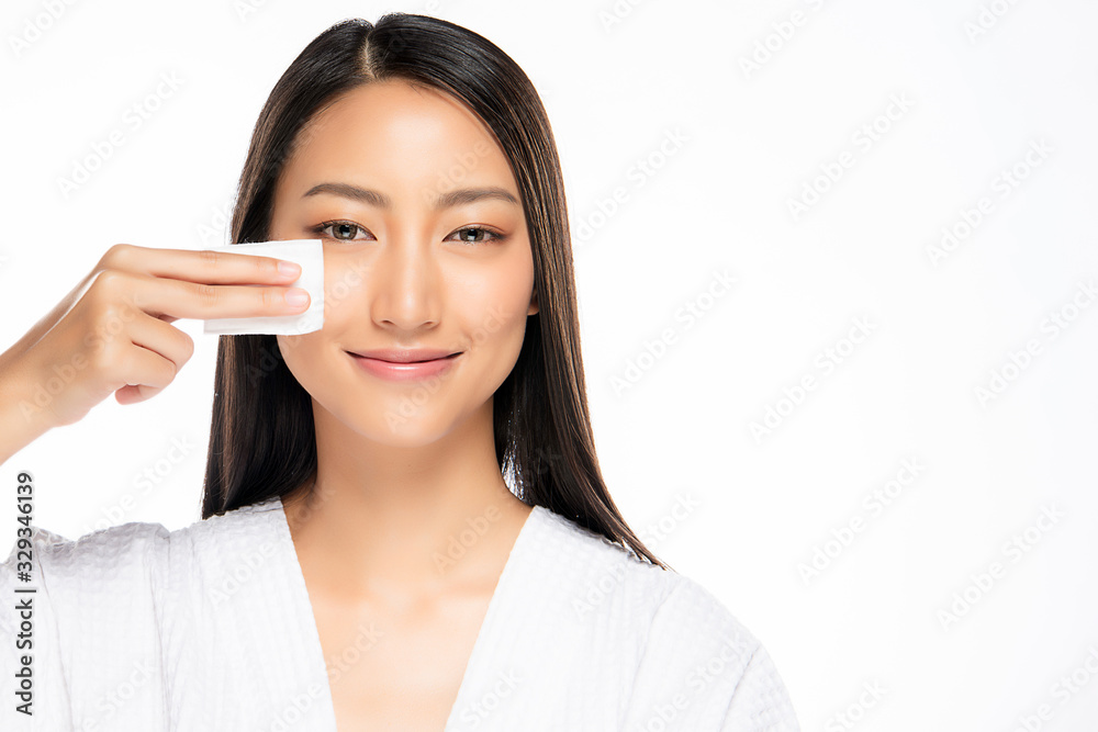 Happy smiling beautiful asian woman using cotton pad cleaning skin, isolated on white background Happy smiling beautiful asian woman using cotton pad cleaning skin, isolated on white background
