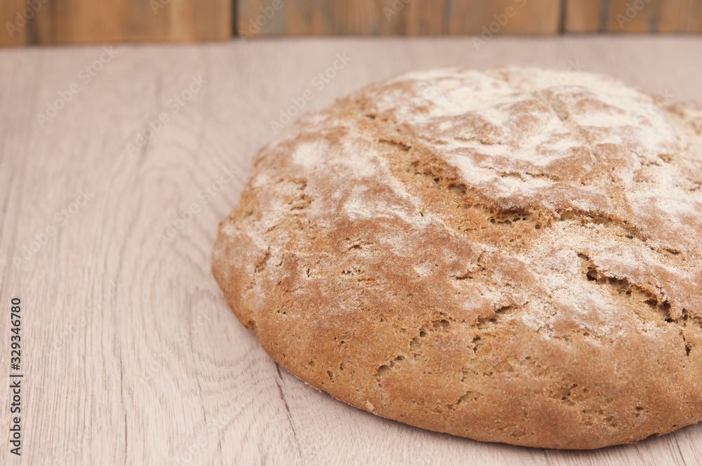 Fototapeta premium Round loaf of freshly backed sourdough bread, with copy space