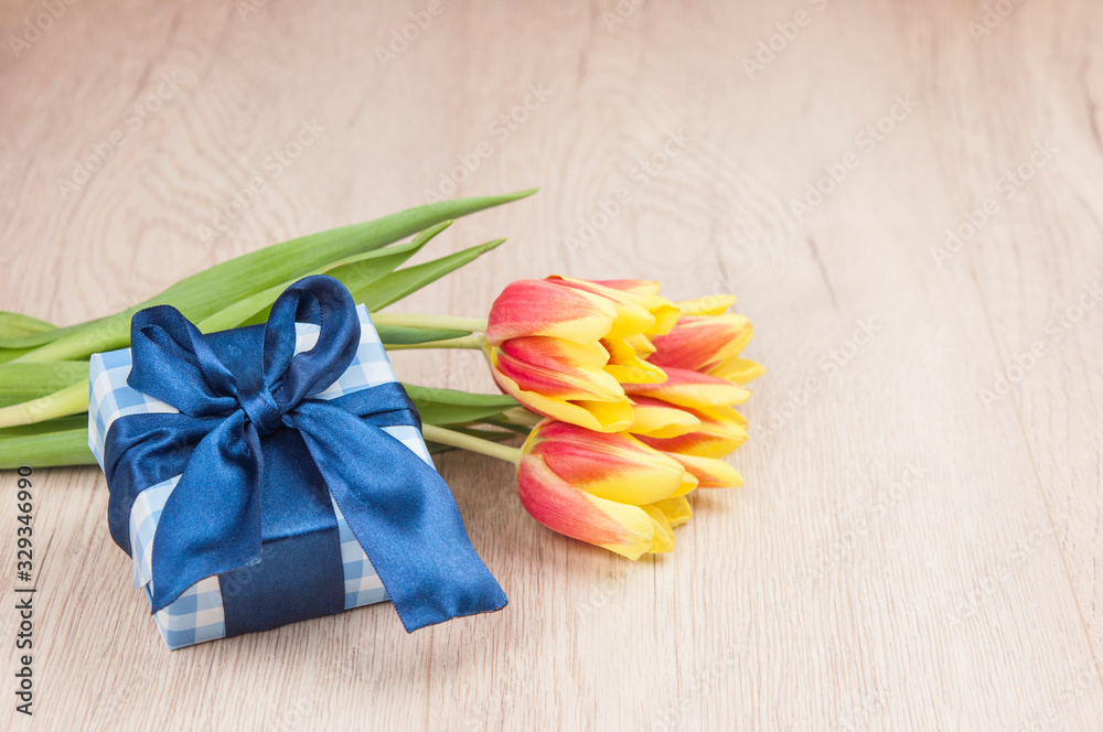 Holidays still life with colorful tulips and gift box Holidays still life with colorful tulips and gift box