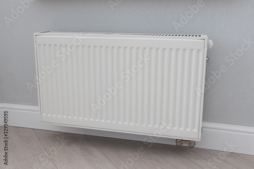 white battery on the wall. Iron radiator. Modern heating system
