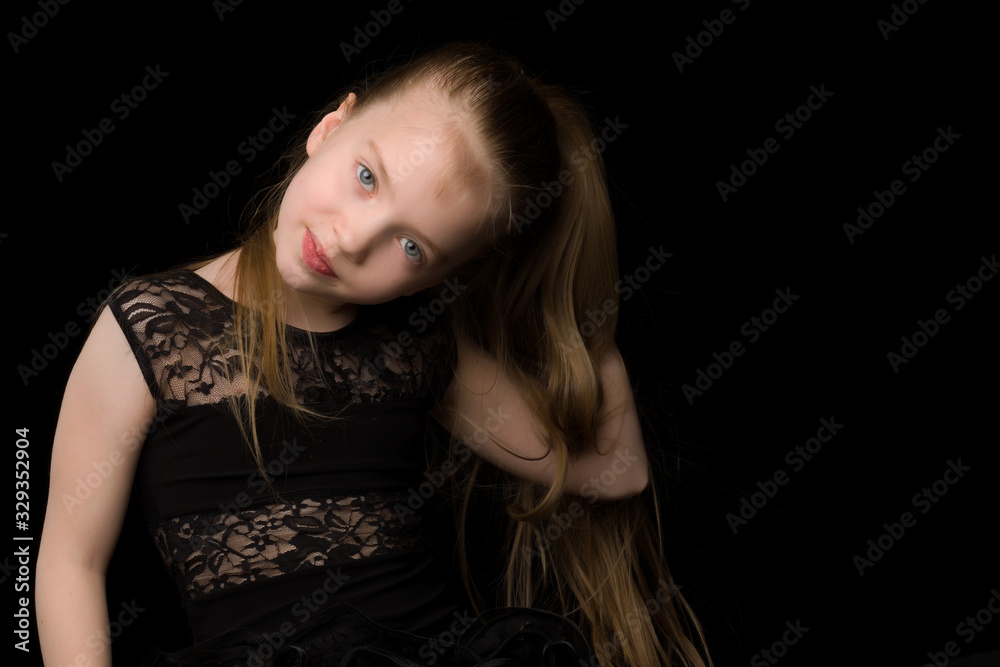 A beautiful little girl straightens her hair on her head. A beautiful little girl straightens her hair on her head.