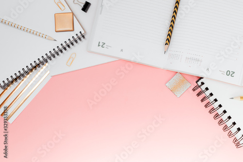 Mockup planner flat lay, top horizontal view pink background. Notepad and notebooks with stationary. Golden, white, pink and black c © Elina