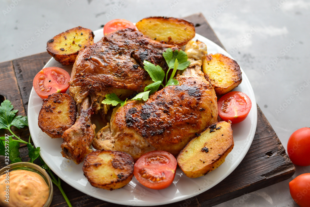 Fried chicken legs in a plate with vegetables. Tasty lunch or dinner. Barbecue, grilled meat. Chicken thighs and drumsticks.