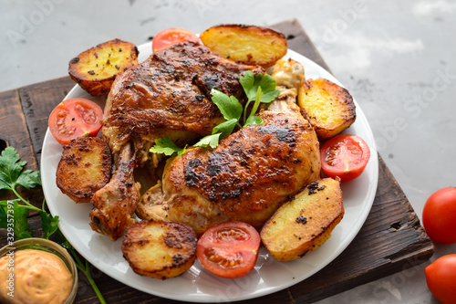 Fried chicken legs in a plate with vegetables. Tasty lunch or dinner. Barbecue, grilled meat. Chicken thighs and drumsticks.