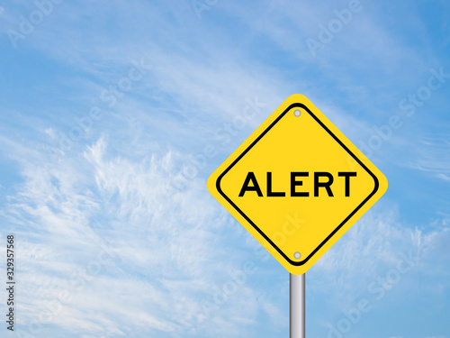 Yellow transportation sign with word alert on blue sky background