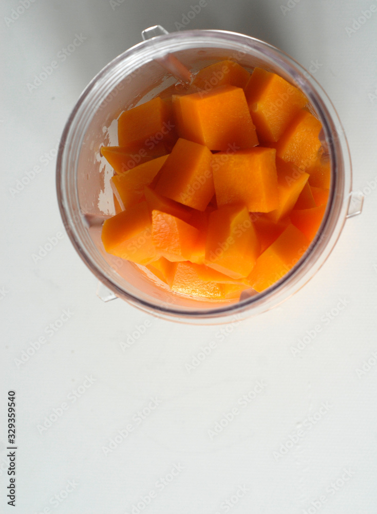 chopped orange pumpkin in a transparent mug