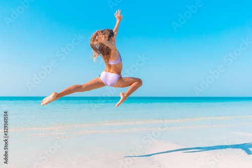 Adorable active little girl at beach during summer vacation