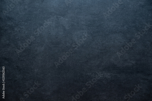 old blackboard concrete stone background texture with light gradient and copy space blue colored