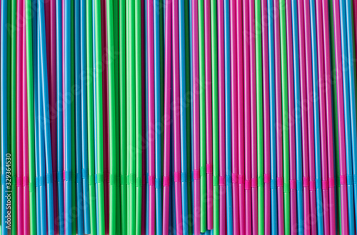 Colorful drink straws on pink background.