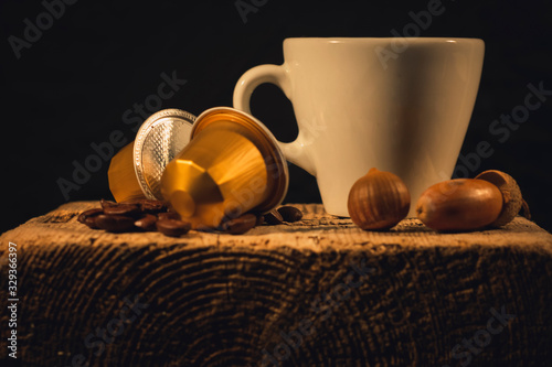 Cup of coffee in woodden background with coffee capusles ands coffee beans