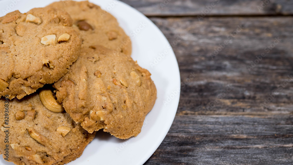 Cashew cookies in a half plate, placed on a wooden table Cashew cookies in a half plate, placed on a wooden table