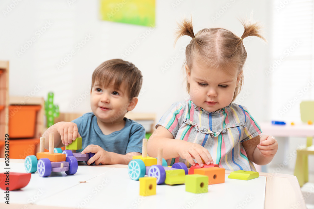 Little children playing with construction set at table Little children playing with construction set at table