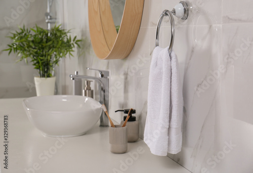 Soft towel on wall above bathroom countertop with toiletries