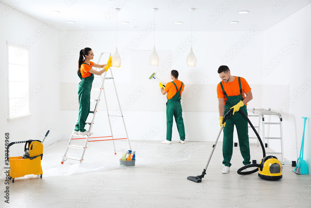 Obraz premium Team of professional janitors cleaning room after renovation