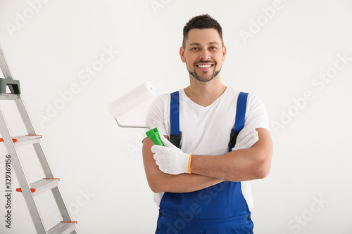 Fototapeta Naklejka Na Ścianę i Meble -  Man holding roller in empty room. Interior renovation