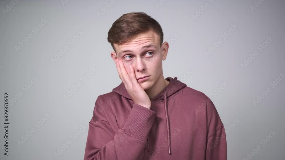 Man in hoodie regretting his wrongdoing over white background Man in hoodie regretting his wrongdoing over white background