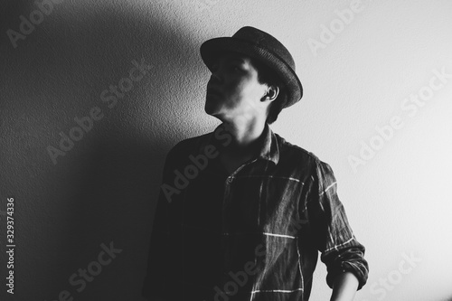 Asian man in Scott shirt and wearing a vintage cap looking on gray background. the darkness of black and white tone