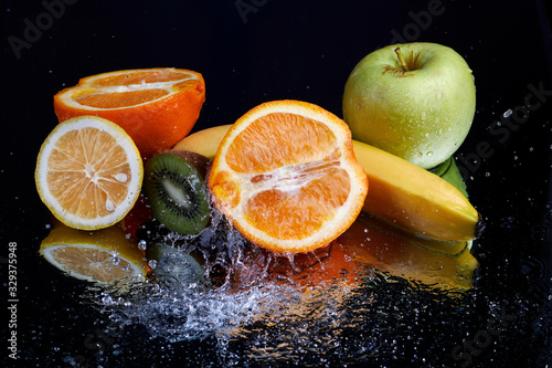 Fototapeta Naklejka Na Ścianę i Meble -  Fruits with water splash on black background