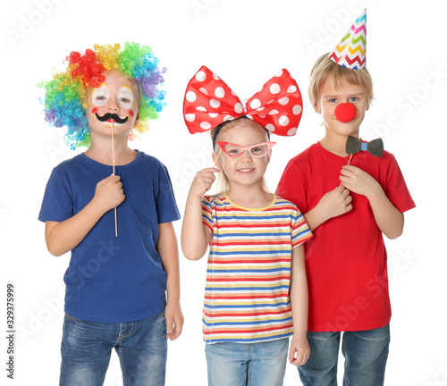 Cute children in funny costumes on white background. April fool s day