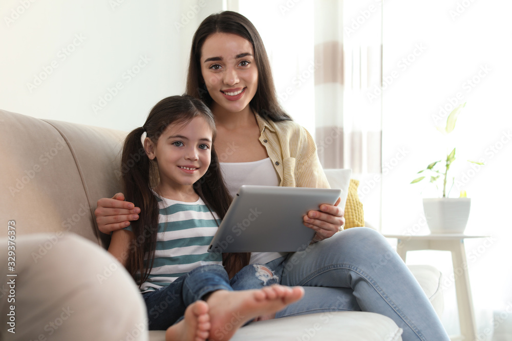 Mother and daughter reading E-book together at home Mother and daughter reading E-book together at home