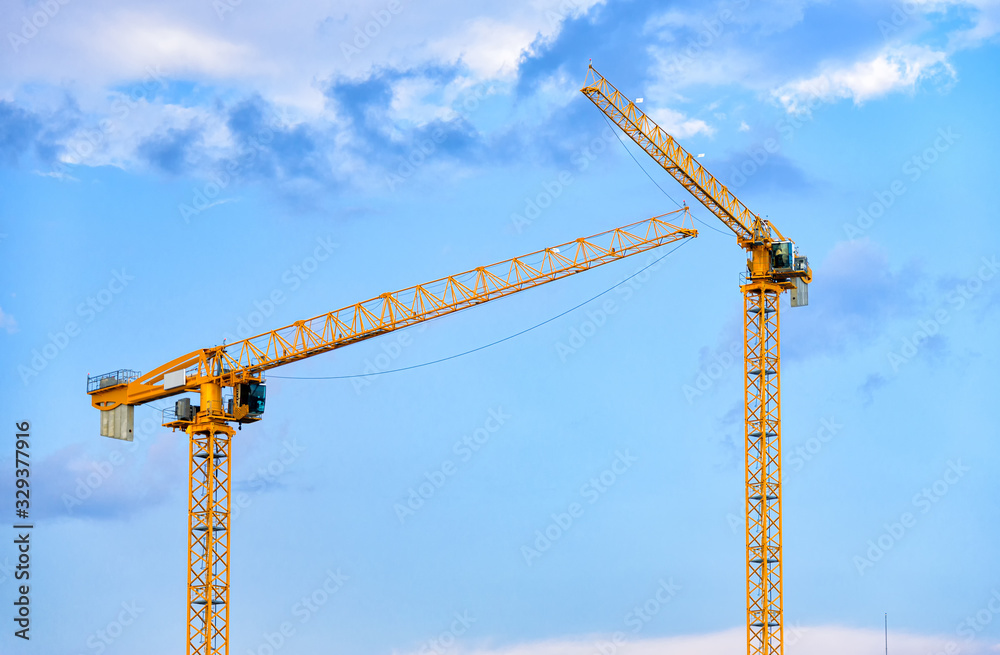 Construction cranes over blue sky Construction cranes over blue sky
