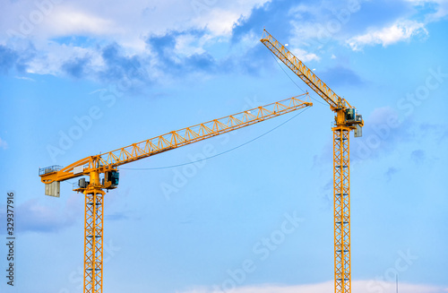 Construction cranes over blue sky