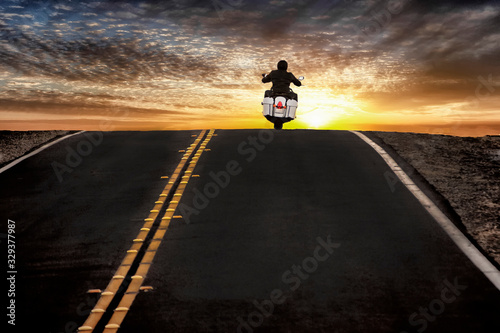 Motorcycle rider on street riding toward sunset sky © F Armstrong Photo