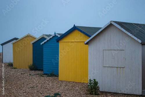 A line of wooden beach huts on a pebble beach © Gary L Hider