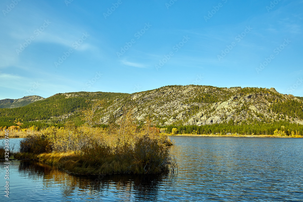 landscape lake and wooded mountains.