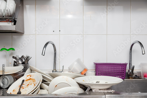 Metal sink full of dirty dishes, crockery, tableware