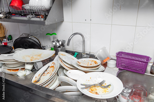 Metal sink full of dirty dishes, crockery, tableware