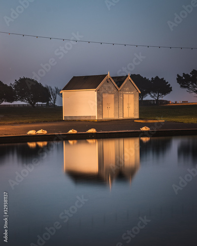 two beach huts near a lake with sleeping swans on the shore at canoe lake southsea photo
