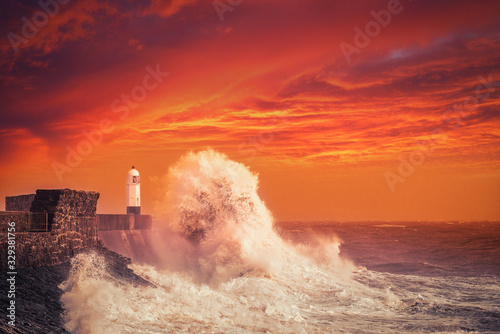 Porthcawl Lightouse and Waves at Sunset in South Wales, United Kingdom photo