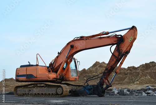 Crawler excavator with hydraulic hammer for the destruction of concrete and hard rock at the construction site.