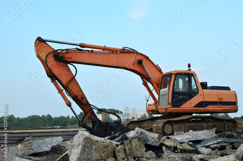 Crawler excavator with hydraulic hammer for the destruction of concrete and hard rock at the construction site.