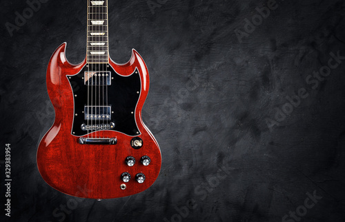 Red electric guitar on a dark grunge background