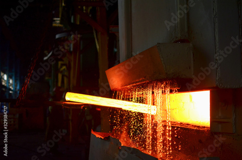 Steel quenching at high temperature in industrial furnace at the workshop of a forge plant. Process of cooling, heat treatmen. Blacksmith and metallurgical industry, steelmaking, hot rolling mill