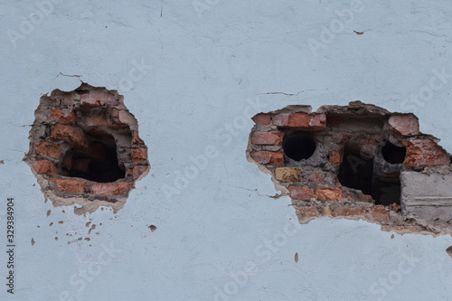 Holes from shells in a brick wall made during the hostilities