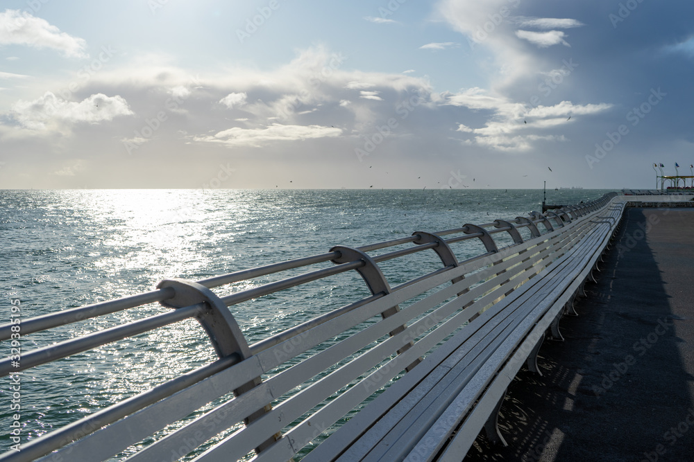 white wooden benches lining a british seaside pier