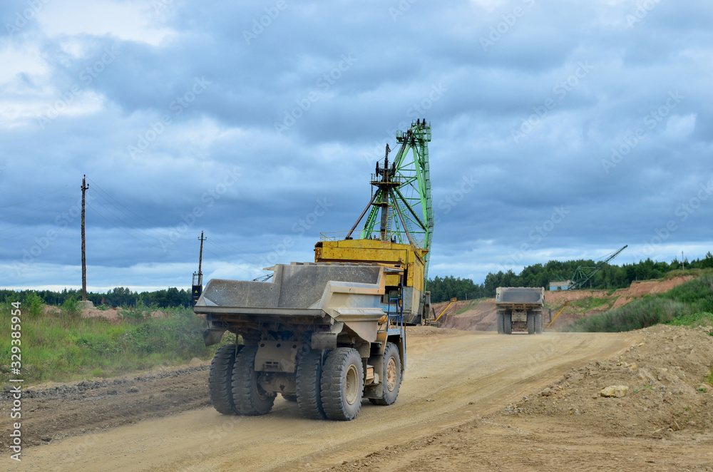 Fototapeta premium Big mining truck transport of minerals in the quarry. Open-cast mining of extracting rock or minerals from the earth. Largest dolomite deposit open-pit mining Gralevo, Belarus, Vitebsk region