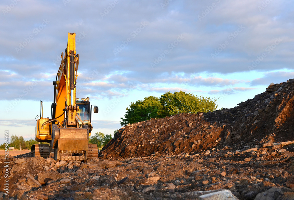 Large tracked excavator works in a gravel pit. Loading of stone and rubble for its processing at a concrete factory into cement for construction work. Cement production factory on mining quarry